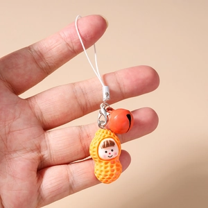 Macro detail of cartoon peanut girl charm with a red bell and durable lobster clasp