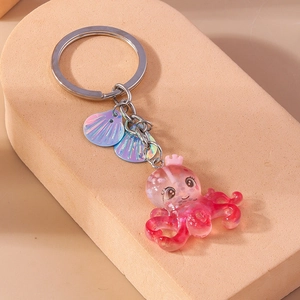 Close-up of pink glitter octopus keychain with sea shells and silver metal keyring