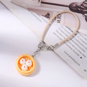 Detailed close-up of a realistic steamed bun food charm with a woven cord strap