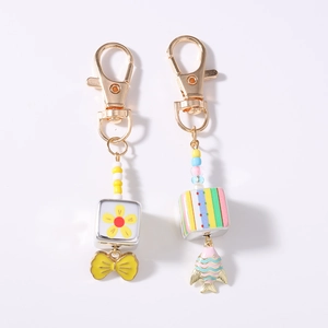 Detail of beaded keychain charms with floral square blocks and colorful goldfish pendants