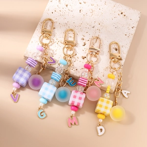 Detailed view of colorful beaded keychains with plaid cubes and frosted round beads