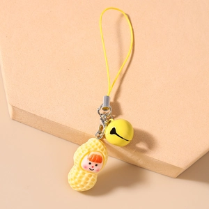 Detail of peanut doll phone strap with yellow bell and metal hook on wooden stand