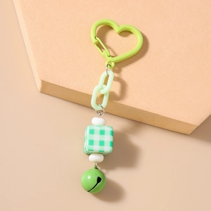 Detailed view of a green checkered square charm keychain with heart clasp and metal bell