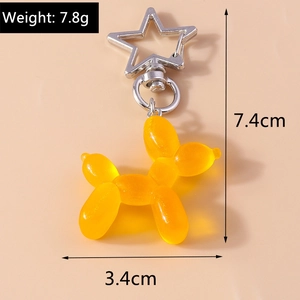 Dettaglio portachiavi a forma di cane palloncino giallo in resina con chiusura a stella