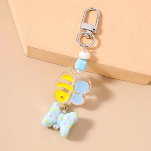 Detail of beaded keychain with yellow bee pendant and polka dot green ribbon bow