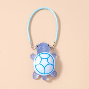 Detailed close-up of light purple resin turtle charm with blue pattern and sky blue cord