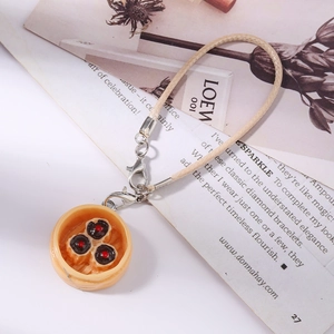 Detail of realistic dumpling food charm inside a mini steamer with a leather cord strap