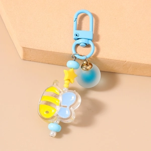 Detail of bee keychain with blue U-hook, yellow star beads, and golden bell charm