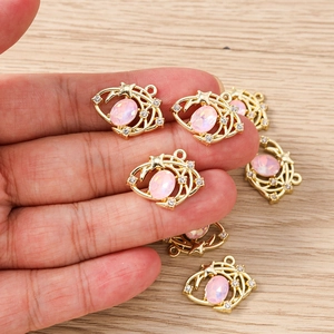 Détail du pendentif céleste doré avec pierre d'opale rose et accents de strass