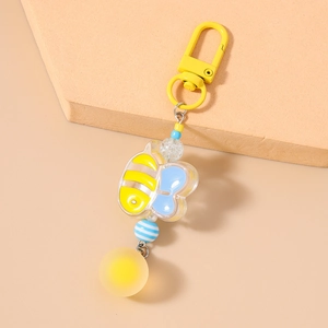 Detailed macro view of a cartoon bee keychain with acrylic beads and yellow orb charm