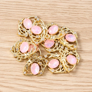 Détail de breloques lune avec pierres roses et strass blancs pour la création de bijoux