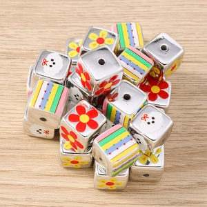 Macro shot of silver cube beads with floral patterns and colorful stripes for DIY jewelry