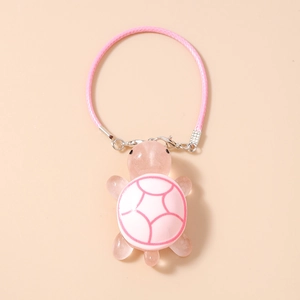Close-up of pink translucent turtle phone charm with silver metal hook and pink braided cord