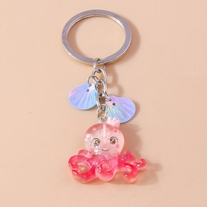Detailed close-up of a pink resin octopus keychain with crown and iridescent shells