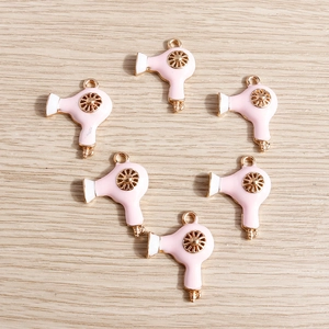 Detailed macro view of pink enamel hairdryer charms for DIY jewelry making accessories