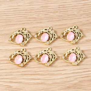 Vue détaillée de pendentifs œil en opale rose avec gravures dorées d'astres et lune