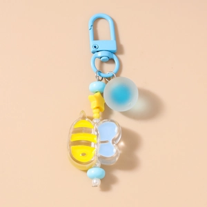Close-up of cute yellow bee acrylic keychain with blue star and bead charms