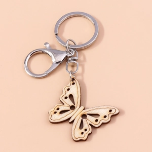 Close-up of laser-cut wooden butterfly keychain with silver metal ring and lobster clasp