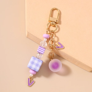 Detailed view of purple beaded keychain with golden lobster clasp and textured beads
