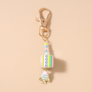 Detailed view of beaded keychain with gold lobster clasp and striped cube fish pendant