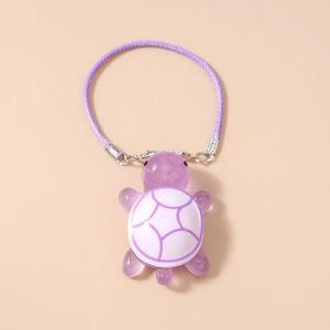 Detailed close-up of a purple resin turtle charm on a matching braided strap