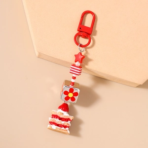 Détail du porte-clés gâteau à la fraise avec perles rayées et breloque florale