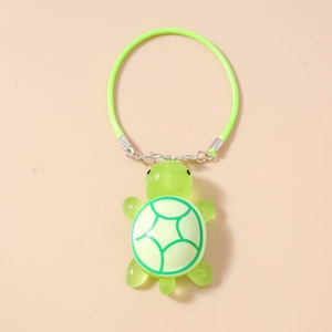 Close-up of a translucent green turtle charm with detailed shell patterns and a lobster clasp