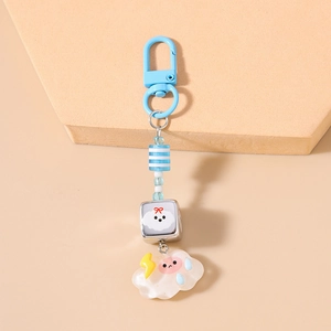 Gros plan sur les perles à rayures bleues et le pendentif nuage sur un porte-clés étoile