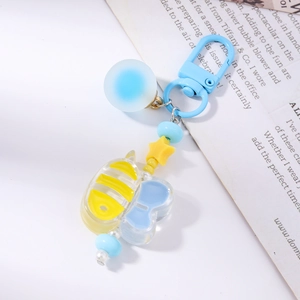 Detail of bee keychain with blue beads and acrylic insect charm for bag decoration
