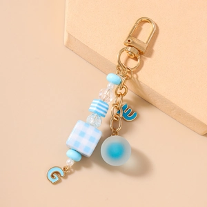 Detail of blue beaded keychain with striped square beads and gold metal clasp