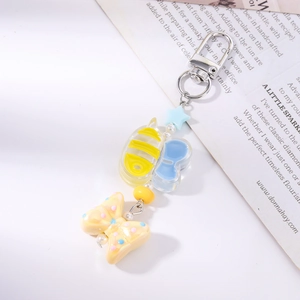 Detail of bee keychain with blue star charm, resin beads, and pink polka dot bow