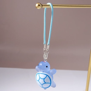 Detail of light blue turtle charm with resin shell texture on braided strap