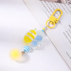 Detail of bee themed keychain with yellow metal hook and blue striped beads