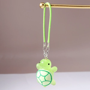 Detailed close-up of a neon green resin turtle charm with green woven lanyard