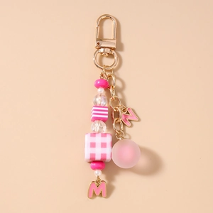 Detailed macro view of pink beaded keychain with letter charms and acrylic beads