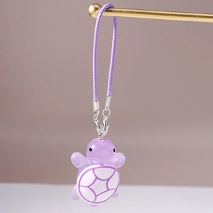 Detailed view of cute purple resin turtle charm with braided rope and metal clasp