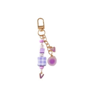 Beaded keychain with purple plaid cubes and golden letter V pendant on white background