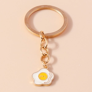 Dettaglio del portachiavi smaltato a forma di uovo fritto con anello in metallo d'oro