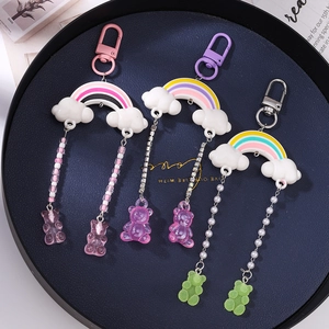 Rainbow cloud bear keychains with tassels and colorful gummy bear pendants on blue tray