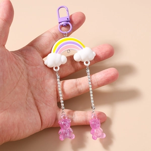 Detailed view of rainbow cloud keychain with purple gummy bear charms and rhinestone chains