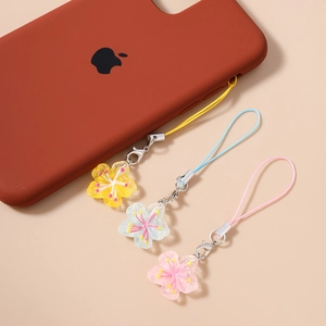 Détail de bijoux de téléphone en résine florale jaune, bleu clair et rose avec clips argentés