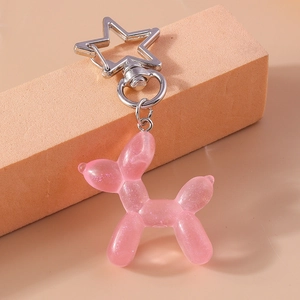 Dettaglio di un portachiavi a forma di cane palloncino in resina rosa con anello a stella