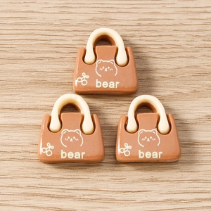 Detail von drei Bären-Handtaschen-Anhängern aus Harz in Karamellbraun für DIY-Schmuck