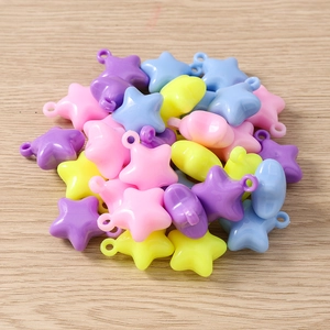 Macro shot of colorful star-shaped acrylic charms for DIY jewelry on wooden background