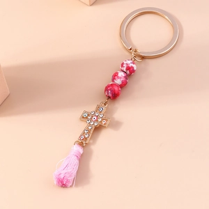 Golden cross keychain with marble beads, evil eye charm and pink silk tassel