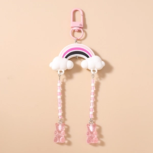 Detail of a rainbow cloud bear keychain with pink beaded tassels and gummy bear charms