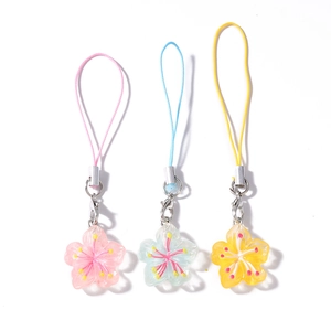 Trois breloques de téléphone en cerisier rose, bleu et jaune avec pendentifs en résine
