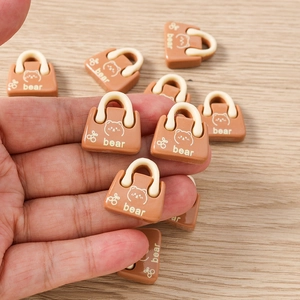 Miniatur Handtaschen-Anhänger in Kaffeebraun mit Bärenmuster zur Größenansicht in der Hand