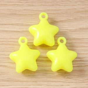 Close-up of three fluorescent yellow star pendants with integrated rings for DIY jewelry