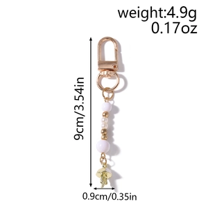 Detail of striped beaded keychain with pearl tassel and jellyfish pendant in gold